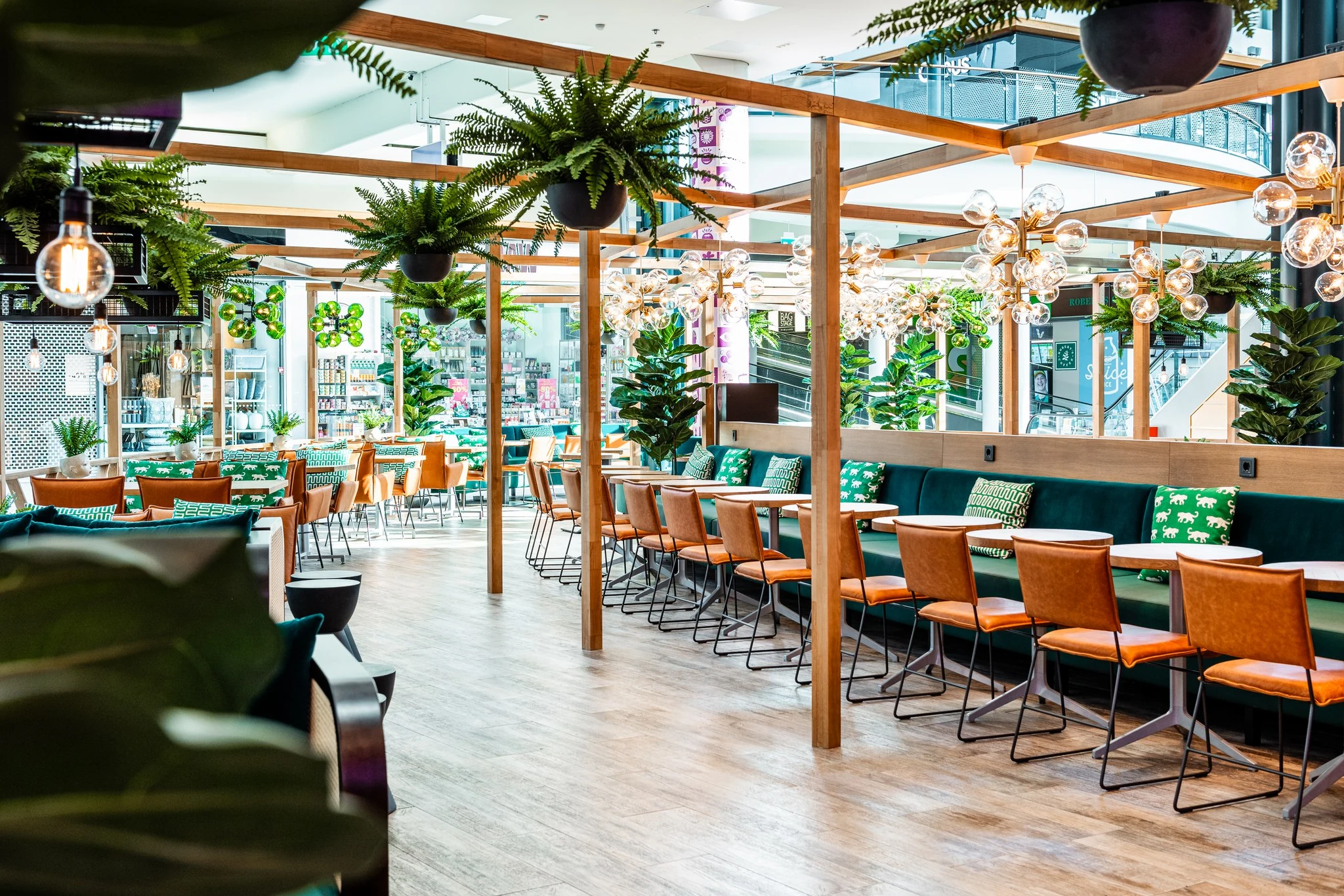 Valgusküllane restoran rippuvate taimede, puitraamide ja sooja rippvalgustusega
